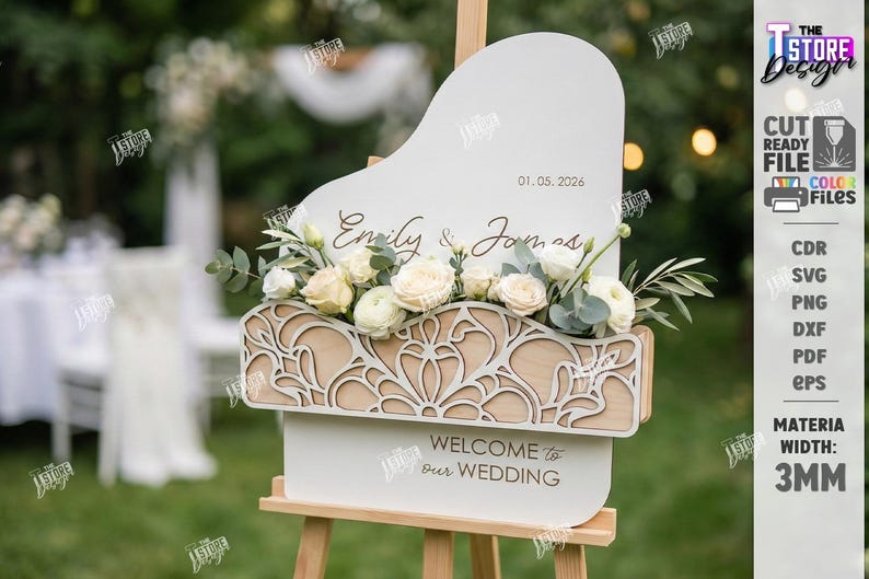 May include: A wooden wedding sign with a white top and a decorative floral arrangement. The sign reads "Emily & James" and "Welcome to Our Wedding". The date "01.05.2026" is also displayed. The sign is supported by a wooden easel.