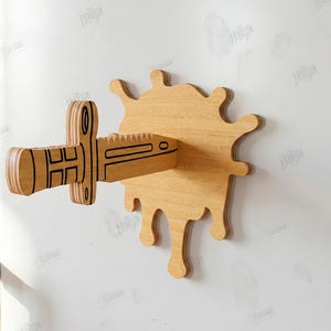 Puede incluir: Decoraci&oacute;n de pared de madera con un dise&ntilde;o de cuchillo que perfora una salpicadura de madera. El cuchillo y la salpicadura son de madera marr&oacute;n claro con detalles negros. Incluye el texto "CUT READY FILE DIGITAL DOWNLOAD".