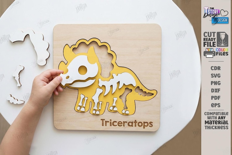K&ouml;nnte beinhalten: Ein h&ouml;lzernes Triceratops-Puzzle mit gelbem und wei&szlig;em Dinosaurierskelett-Design. Das Puzzle befindet sich auf einer hellen Holzbasis, mit dem Wort "Triceratops" unten. Das Bild zeigt auch die Hand einer Person, die ein Puzzleteil einsetzt.