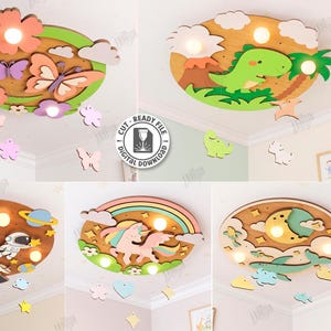 Könnte beinhalten: Fünf lasergeschnittene Holzdesigns für die Kinderzimmerdekoration. Die Designs umfassen ein Schmetterlingsthema, eine Dinosaurierszene, einen Astronauten und eine Rakete, ein Einhorn mit einem Regenbogen und eine Mond- und Wolkenszene. Kompatibel mit jeder Materialstärke.