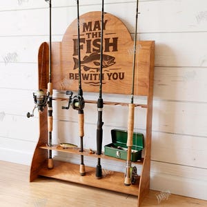 May include: Wooden fishing rod rack with the text "MAY THE FISH BE WITH YOU" and a fish graphic. The rack holds four fishing rods, a tackle box, and a lure. The material width is 6mm.