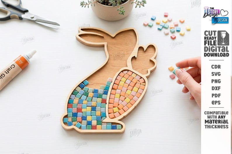 May include: Wooden bunny-shaped tray with a carrot-shaped section, filled with colorful mosaic tiles. The tray is surrounded by craft supplies and small plants. The image also includes the text "CUT READY FILE DIGITAL DOWNLOAD".