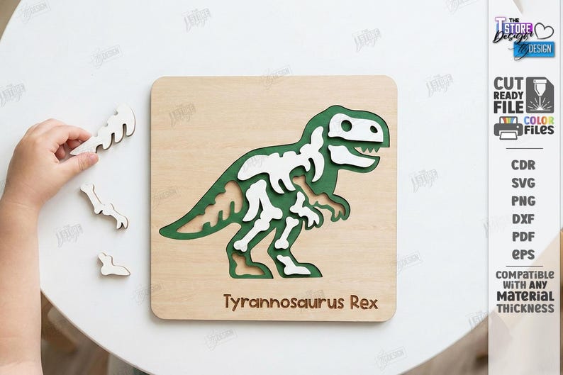 K&ouml;nnte beinhalten: Holzpuzzle Tyrannosaurus Rex mit gr&uuml;nem und wei&szlig;em Dinosaurierskelett-Design. Die Puzzleteile werden auf einer hellbraunen Holzbasis zusammengesetzt. Der Text "Tyrannosaurus Rex" befindet sich am unteren Rand des Puzzles.