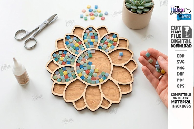 May include: A wooden sunflower-shaped craft project with a mosaic tile design. The project is partially filled with colorful square tiles. Scissors, glue, and a small succulent plant are also visible. The text "CUT READY FILE DIGITAL DOWNLOAD" is on the right.