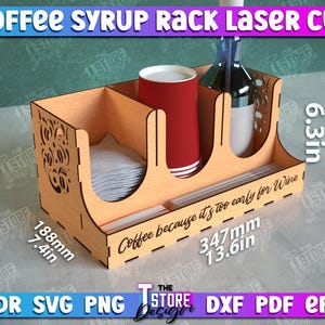 May include: Laser cut wooden coffee syrup rack with a red cup, a bottle, and a compartment for napkins. The rack measures 7.4 inches tall, 13.6 inches wide, and 6.3 inches deep. It has the text "Coffee because it's too early for wine" on the front.