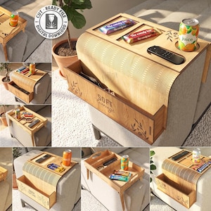 Pode incluir: Uma bandeja de madeira clara para braço de sofá com design flexível de ripas, apresentando um porta-copos embutido, um compartimento para controle remoto e um espaço de armazenamento lateral. A superfície de madeira tem gravado "SOFT evenings".