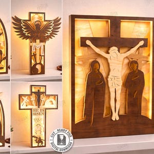 May include: A collection of five laser-cut wooden designs, including crosses and religious figures. The designs are illuminated from behind, creating a warm glow. The main image features a depiction of the crucifixion. The text "HE IS RISEN" is visible on one design.