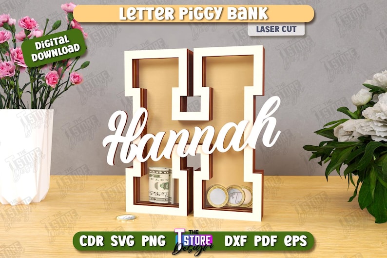 Puede incluir: Una hucha de madera con forma de letra "H" con el nombre "Hannah" en escritura blanca. El banco contiene billetes enrollados y monedas. Las palabras "Letter Piggy Bank" y "Laser Cut" est&aacute;n en la parte superior.