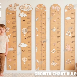 May include: Wooden growth chart rulers with decorative cutouts of whales, clouds, hot air balloons, and butterflies. The rulers measure up to 150 inches and are marked in inches and centimeters. The image also includes the text "CM & INCH" and "GROWTH CHART RULER."