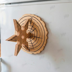 Puede incluir: Decoraci&oacute;n de pared de madera en forma de estrella con dise&ntilde;o de anillos de &aacute;rbol. La estrella est&aacute; hecha de madera en capas y tiene un acabado natural. La decoraci&oacute;n est&aacute; montada sobre una superficie blanca. El texto "CUT READY FILE DIGITAL DOWNLOAD" es visible.