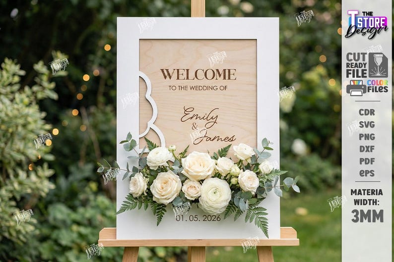 May include: A wooden wedding welcome sign with the text "WELCOME TO THE WEDDING OF Emily & James" and the date 01.05.2026. The sign is framed in white and decorated with white roses and greenery. The sign is on an easel.