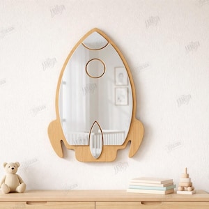 May include: A wooden rocket-shaped mirror with a clear reflective surface. The mirror has a light brown frame with cut-out details and a circular and oval shape. The text "CUT READY FILE" and "MATERIAL WIDTH: 3MM" are visible.