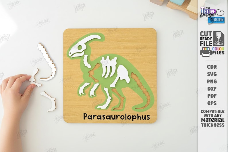 K&ouml;nnte beinhalten: Ein Holzpuzzle mit einem gr&uuml;nen Parasaurolophus-Dinosaurier mit wei&szlig;en und braunen Knochen. Das Puzzle befindet sich auf einer hellbraunen Holzbasis, auf der der Name des Dinosauriers aufgedruckt ist. Einige Puzzleteile sind separat.