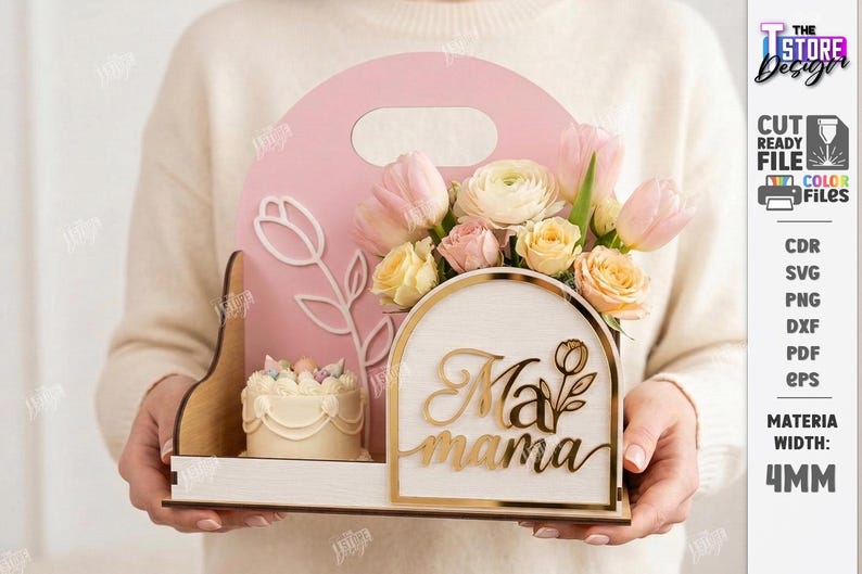 May include: A pink wooden Mother's Day gift box with a handle, holding a floral arrangement of pink and yellow flowers, a small cake, and the words "Ma mama" in gold script. The box has a tulip design.