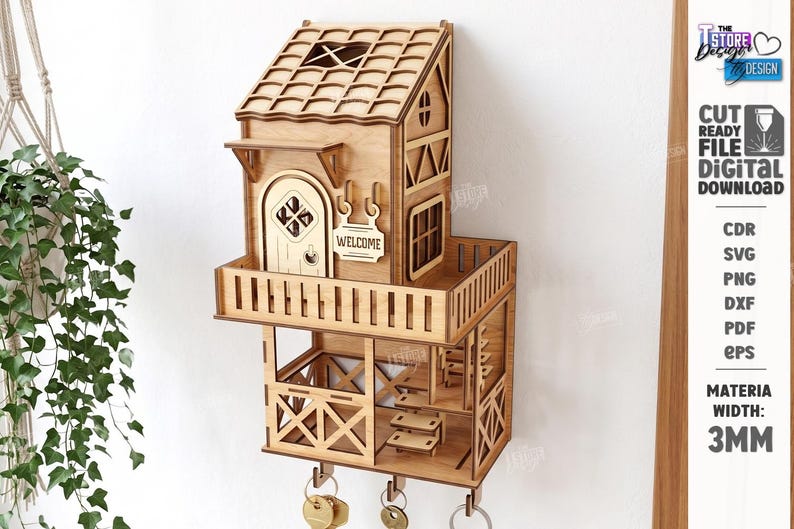 May include: A light brown wooden wall-mounted key holder shaped like a two-story house with a balcony, a door with the text WELCOME, and three metal hooks at the bottom. The structure features laser-cut details, a tiled roof, and a staircase.