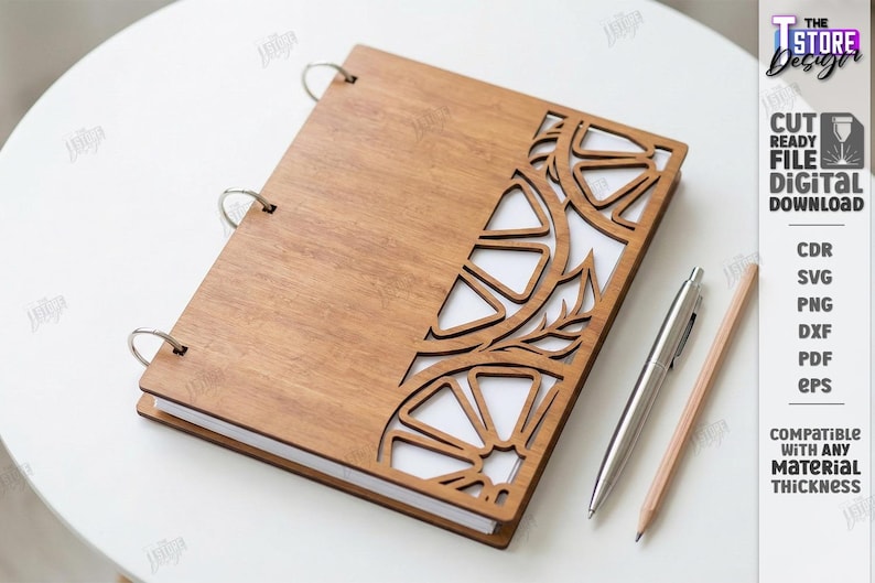May include: A wooden notebook with a laser-cut design of citrus fruit and leaves. The notebook is open, revealing white pages. A silver pen and a wooden pencil are placed next to the notebook. The image also includes the text "CUT READY FILE DIGITAL DOWNLOAD".