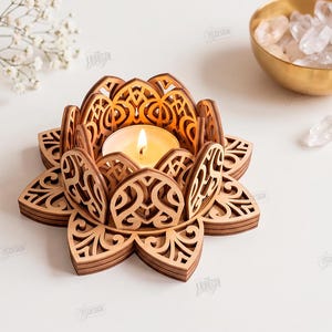 May include: A laser-cut wooden lotus flower candle holder with intricate filigree patterns, holding a lit tea light candle. The text on the right reads: THE STORE DESIGN, CUT READY FILE DIGITAL DOWNLOAD, CDR, SVG, PNG, DXF, PDF, EPS, COMPATIBLE WITH ANY MATERIAL THICKNESS.