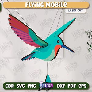 May include: A laser-cut hummingbird mobile with teal, red, and purple wings. The mobile is suspended by strings and features the text "FLYING MOBILE" and "LASER CUT". The image also includes the text "AGEN TOTO MACAU DOWNLOAD" and file type options.