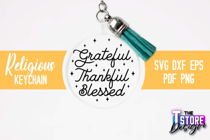 Pu&ograve; includere: Un portachiavi circolare bianco con il testo "Grateful Thankful Blessed" in scrittura nera. Il portachiavi ha un nappina turchese.