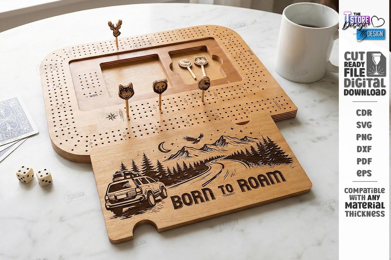 K&ouml;nnte beinhalten: Ein h&ouml;lzernes Cribbage-Brett mit passendem Deckel mit einem Roadtrip-Design und dem Text "BORN TO ROAM". Das Brett enth&auml;lt tierf&ouml;rmige Stifte und einen Stauraum. Eine wei&szlig;e Tasse und W&uuml;rfel sind ebenfalls sichtbar.