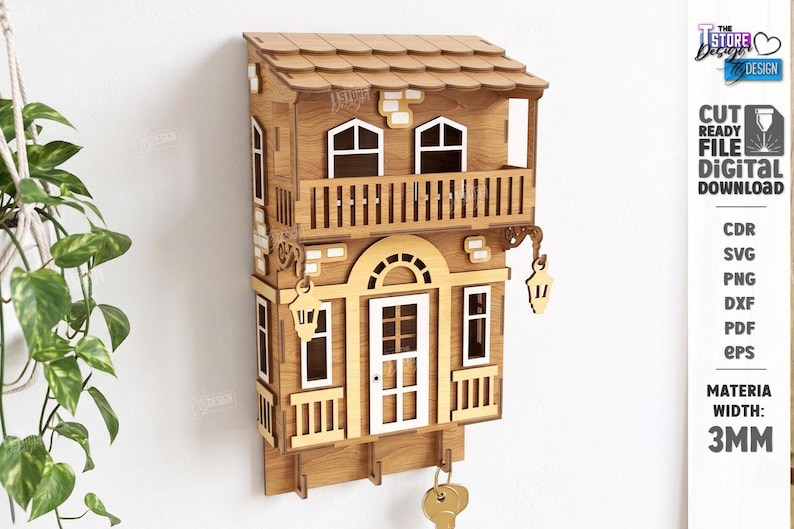 May include: A laser-cut wooden wall-mounted key holder shaped like a two-story house with a balcony, white window frames, and a white door. The structure features two hanging lanterns, three hooks at the bottom, and a 3mm material width label.