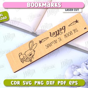 May include: A wooden bookmark with a laser-cut design of a bunny holding a carrot. The bookmark has the text "The book is always better" and "Happy" written on it.