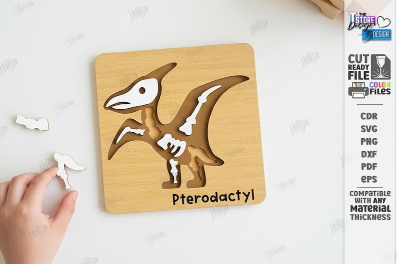 K&ouml;nnte beinhalten: Holzpuzzle Pterodactyl mit Dinosaurier-Skelett-Design. Das Puzzle ist hellbraun mit wei&szlig;en und braunen Details. Das Wort "Pterodactyl" ist unten aufgedruckt. Enth&auml;lt schnittfertige Dateien.