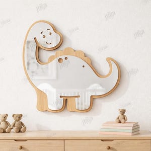 May include: A wooden dinosaur-shaped mirror with a smiling face, suitable for a child's room. The mirror is surrounded by a light wood frame. The image also shows two small teddy bears and a stack of books. The text on the right says "CUT READY FILE".