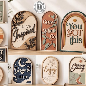 May include: A collection of ten layered wooden wall signs featuring various shapes including arches, circles, and rectangles. The designs display motivational text such as Believe in Yourself, Rise and Shine, Start Today, Live Inspired, and You Got This.