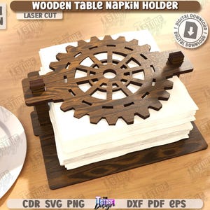 May include: Wooden table napkin holder with a gear-shaped top. The laser-cut design is made of dark brown wood and holds a stack of white napkins. The text "WOODEN TABLE NAPKIN HOLDER" is visible.