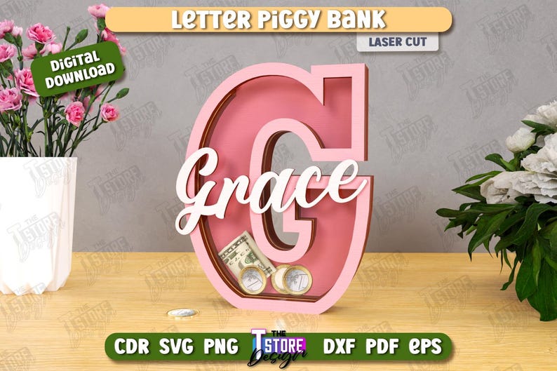 Puede incluir: Una hucha de madera rosa con forma de la letra "G" con el nombre "Grace" en escritura blanca. El banco contiene dinero y monedas. Las palabras "Letter Piggy Bank" y "Laser Cut" est&aacute;n en la parte superior.