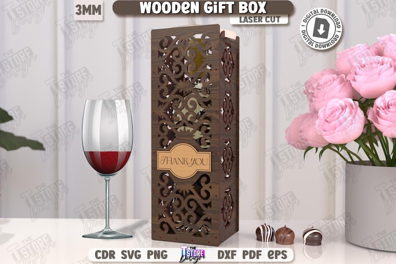 May include: A laser-cut wooden gift box with an intricate design, featuring the text "THANK YOU" on a label. A wine glass with red wine and a bouquet of pink roses are also present. The box is designed for a digital download.
