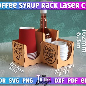 May include: Laser cut wooden coffee syrup rack with a brown and white design. The rack has a compartment for a bottle of syrup, a compartment for cups, and a compartment for lids. The rack is 6.3 inches tall, 9.1 inches wide, and 9.1 inches deep. The rack has the text "Coffee is always a good idea" on the front.