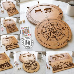 May include: A selection of laser-cut wooden game boards and accessories. Designs include a compass with "Let's Play!", camping scenes, and outdoor themes. The image also shows playing cards, dice, and mugs.
