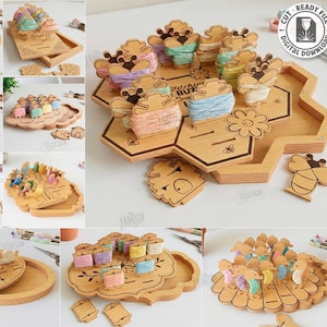 May include: A collection of wooden craft organizers in various shapes, including trays and hexagonal designs. Each organizer holds spools of colorful thread. The image also includes laser cut designs of bees and flowers. The text "10 Designs" is visible.