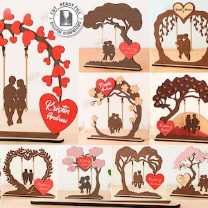 May include: A collection of laser-cut wooden designs featuring couples on swings, trees, and heart-shaped frames. Each design includes a heart with a name. The designs are suitable for weddings or anniversaries.