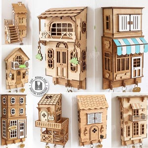 May include: A collection of ten laser-cut wooden wall-mounted key holders designed as miniature house facades. Each piece features intricate architectural details like balconies, windows, and doors, with some including hooks for keys and 3mm material width.