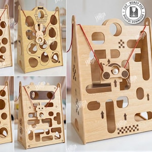 Può includere: Una collezione di cinque modelli in legno tagliati al laser per giocattoli per bambini. Ogni giocattolo presenta un design unico, tra cui un canestro da basket, un coniglio con un cestino, un'auto, un maiale e un robot. Il testo "CUT READY FILE DIGITAL DOWNLOAD" è visibile.