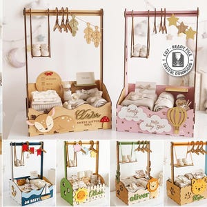 May include: A collection of laser-cut wooden baby clothing racks and storage boxes featuring various decorative themes like deer, hot air balloons, and animals. The designs include hanging bars with miniature hangers, small swings, and personalised text.