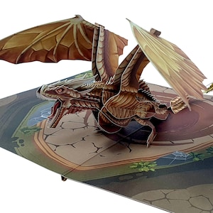 May include: A pop-up card showing a brown dragon with detailed wings. The dragon is depicted with an open mouth. The card's background shows a stone-paved area with a circular structure. The dragon is the central focus of the card.