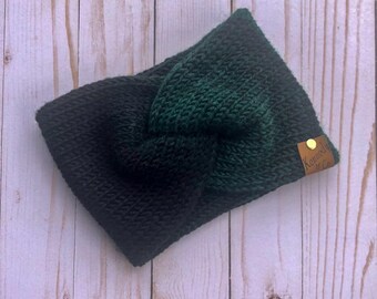 May include: A black and green knit headband with a knotted design. The headband has a small brown leather tag with the text "Kennedy & Co."