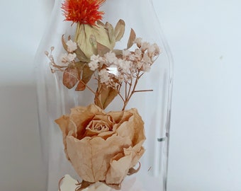Champagne rose in clear glass bottle, dry rose in bottle with warm white light . Home decor, gift for people .