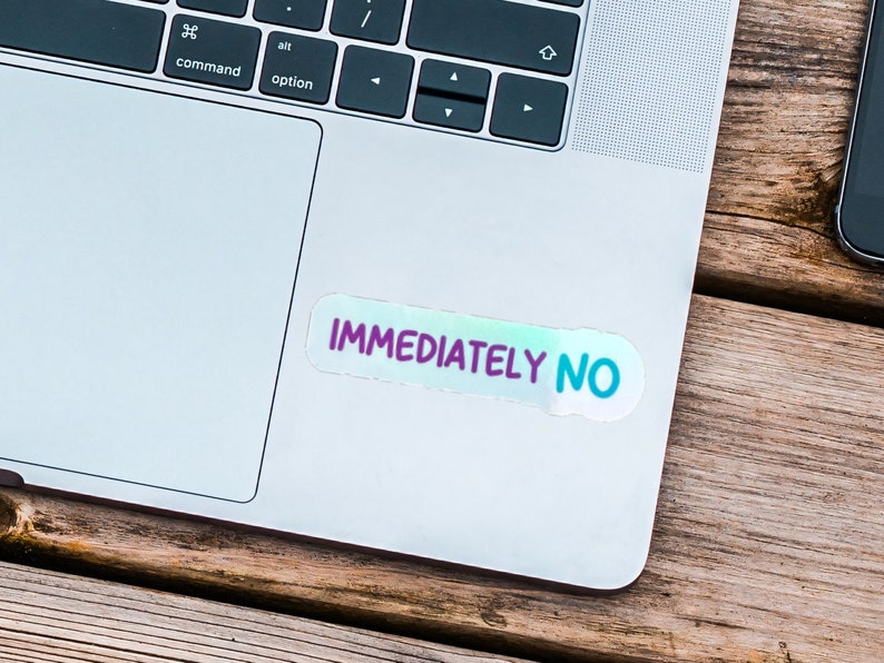 May include: A silver laptop computer with a sticker that says "IMMEDIATELY NO" on the top right corner of the trackpad.
