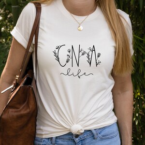 May include: White t-shirt with black text that reads "CNA life" with floral accents.