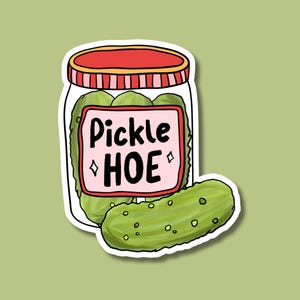 May include: A sticker featuring a jar of pickles with a red lid and the text "Pickle HOE" on a pink label. A single pickle is next to the jar. The background is a light green color.