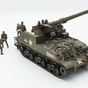 以下が含まれることがあります： 長い砲身と兵士の乗組員を備えた、アメリカ陸軍M7プリースト自走榴弾砲の精密なモデル。モデルは緑色の迷彩パターンで塗装されており、「Courageous Confederate」の文字が刻まれています。