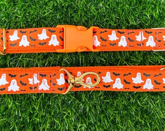 May include: Orange Halloween-themed dog collar and leash set. The collar features a white ghost and black bat pattern. The leash has a gold-colored clasp. The set is made of durable material.
