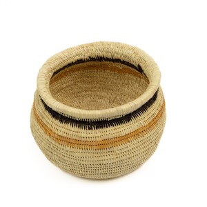 May include: A woven basket with a round shape and a natural beige color. The basket has black and orange stripes around the rim.