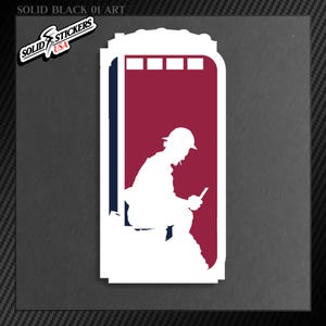 May include: A white sticker with a silhouette of a person in a port-a-potty, holding a phone. The background is red with a blue border. The sticker has the text "SOLID STICKERS USA" in the upper left corner. The text "SOLID BLACK 01 ART" is at the top.