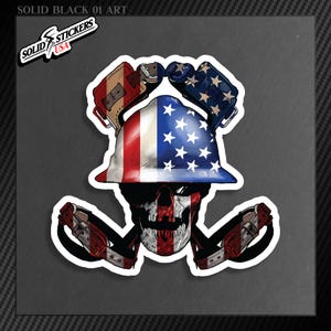 May include: A sticker featuring a skull wearing a hard hat and boxing gloves, all decorated with the American flag. The skull has a red and white striped face. The sticker also includes the text "SOLID STICKERS USA".
